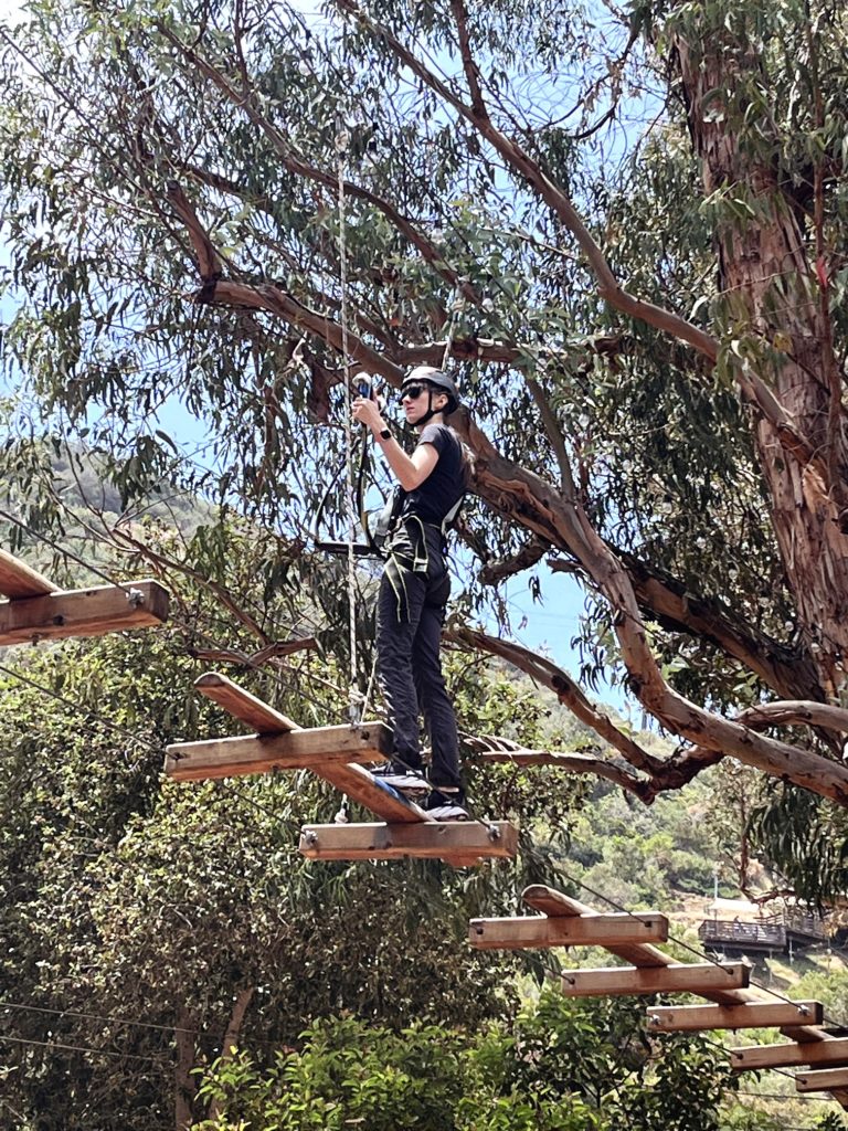 Gabi, The Fringe Explorer, crossing a set of mini log bridges on the aerial obstacle course