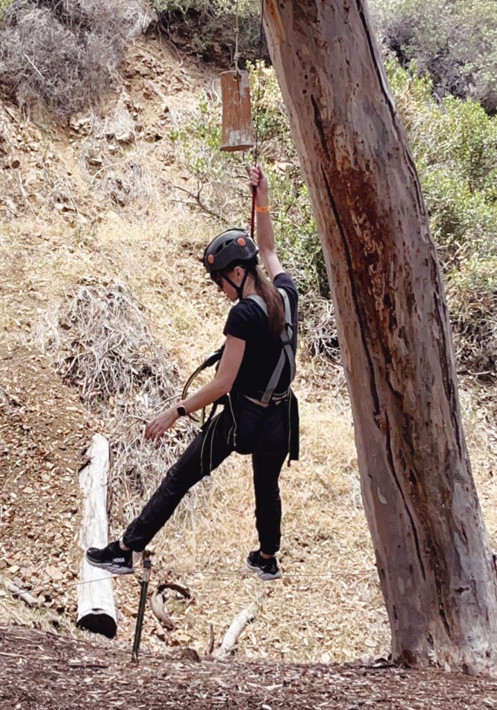 Gabi, The Fringe Explorer, using the auto belay to descend from the obstacle course