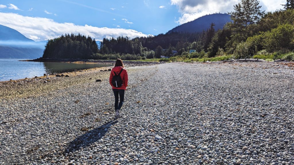 Gabi, The Fringe Explorer, walking along a stone beach in Haines Alaska