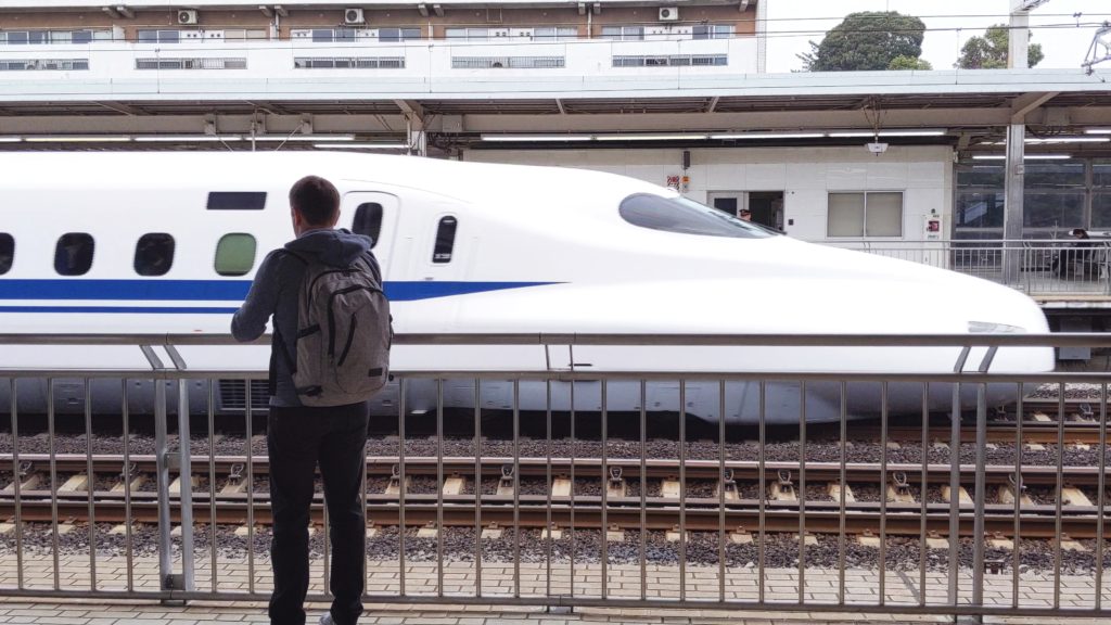 John, The Fringe Explorers Husband, watching a Shinkansen (Bullet Train) speed through the station.