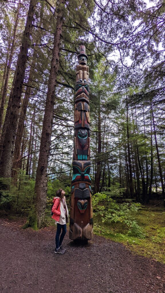 Gabi, The Fringe Explorer, looking up at a totem pole in Sitka