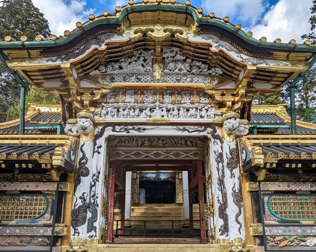 Ornate gold and white gate at the entrance to Toshogu Shrine