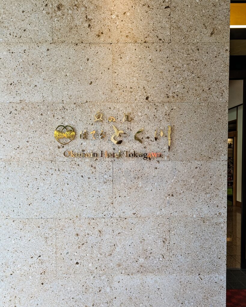 gold lettered sign with the hotel name, Okunoin Hotel Tokugawa, at the entrance