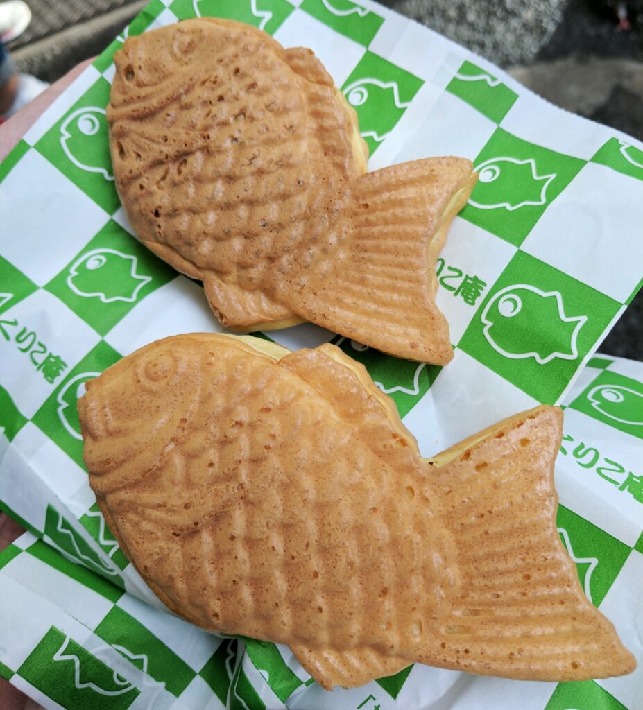 two fried fish shape cakes sitting on top of a checkered green and white wrapper