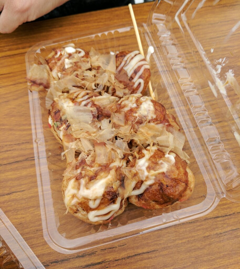 Festival style takoyaki - 6 takoyaki fried balls in a plastic container with Japanese mayo drizzled on top and bonito flakes