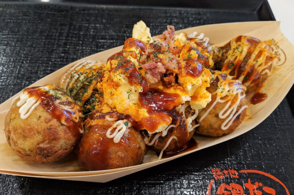 Takoyaki - round friend balls with sauce and potato salad on top