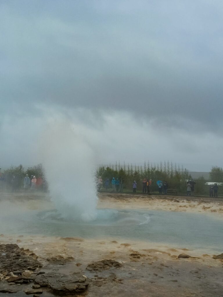 The beginning of an eruption at Strokkur geyser. Water has spouted out of the geyer approximately 10 feet into the air.