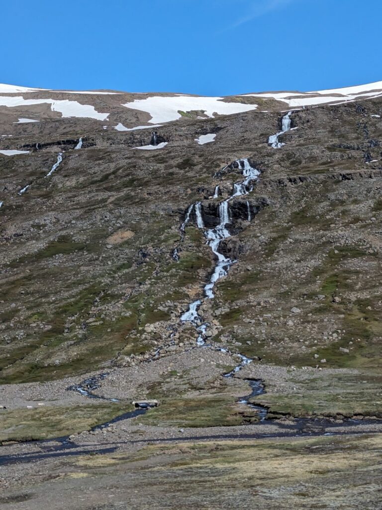 Narrow waterfall cascading in multiple levels down a mountain side