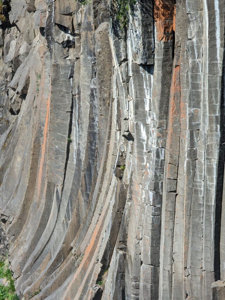 Up close shot of the grey and orange basalt columns in the canyon