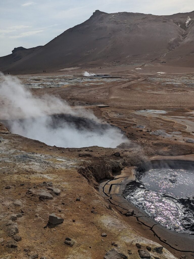 bubbling streaming mud pits in a geothermal area. Red dirt