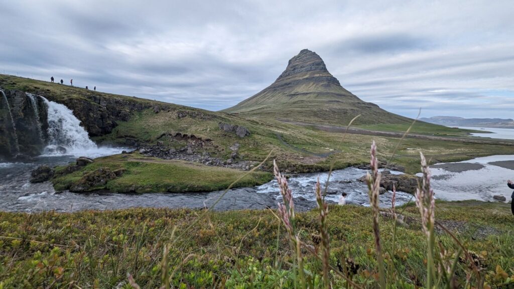 Arrowhead shamed mountain in the background with a waterfall and river in the foreground.