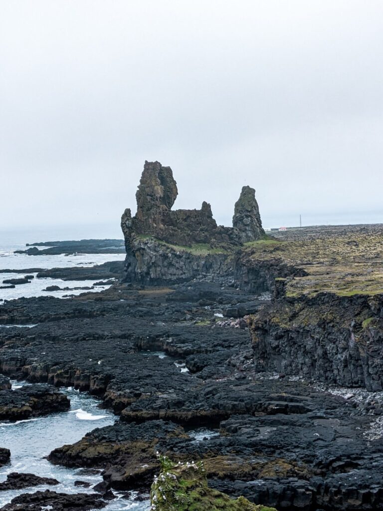 Jagged black lava rock formations jutting out of the seaside