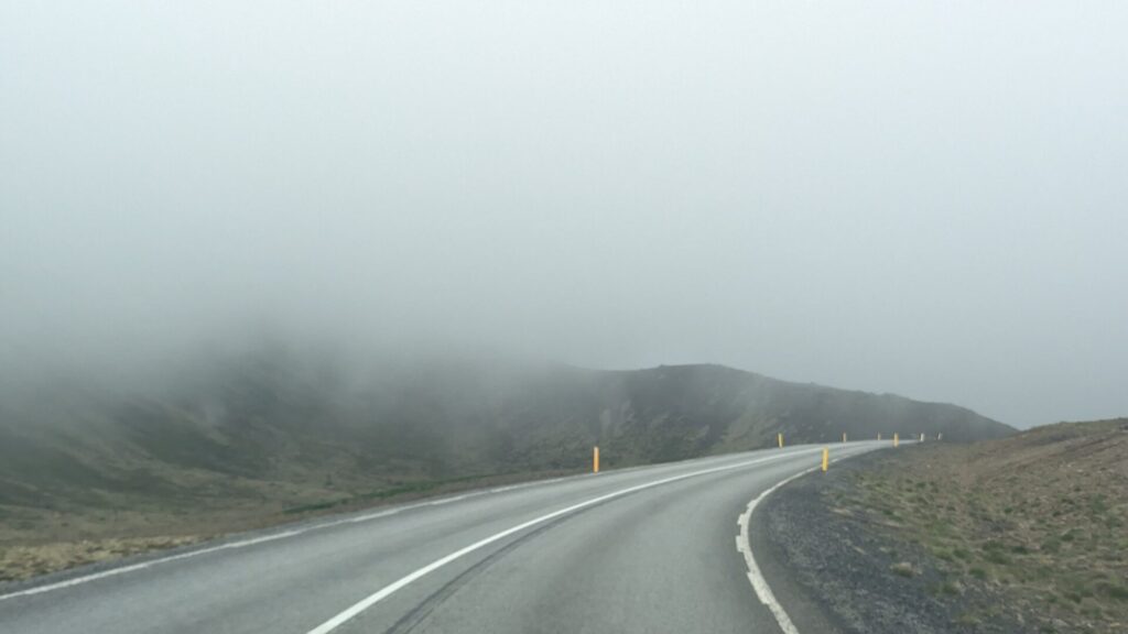 Driving up a road in the fog.