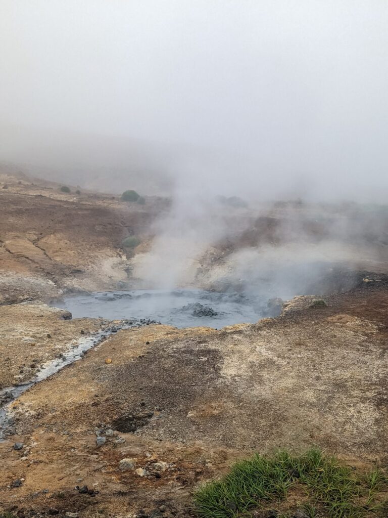 geothermal area with bubbling steaming mud pools