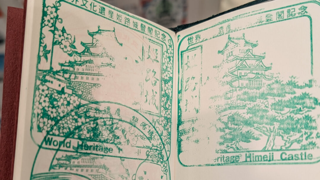 Green ink stamps in a book, they depict Himeji castle with flowers and grass 
