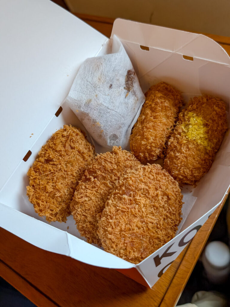 5 fried croquettes in a box sitting on a table