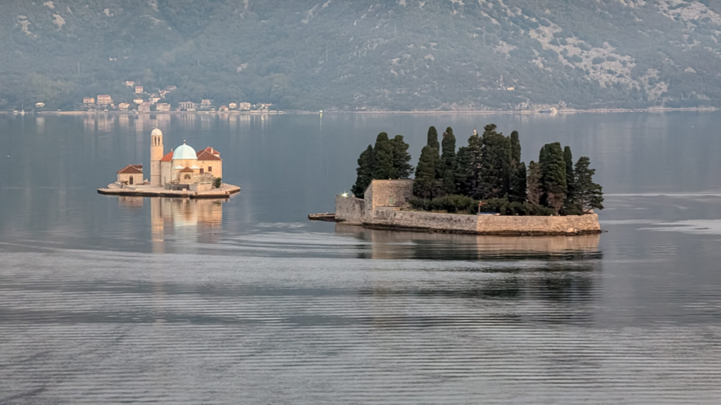 Our Lady of the Rocks and the cypress-covered Saint George Island floating in the Bay of Kotor, Montenegro, seen during the morning sail-in.