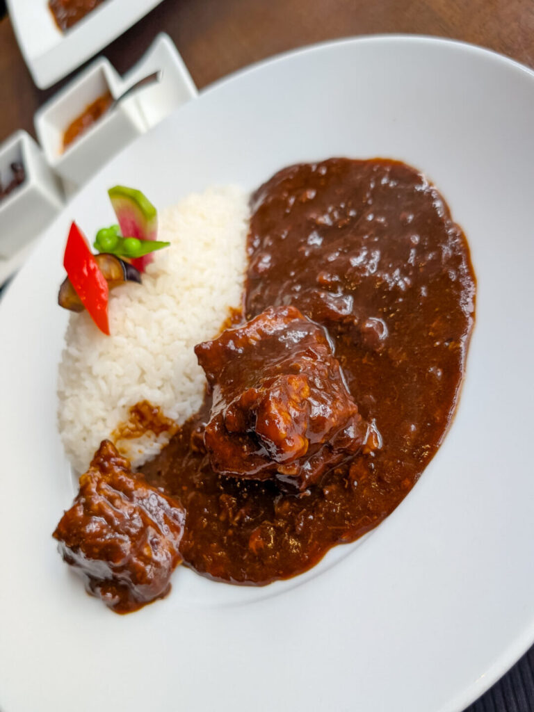 Plate of Japanese beef curry served with rice and garnish at Nara Sanjo Curry.