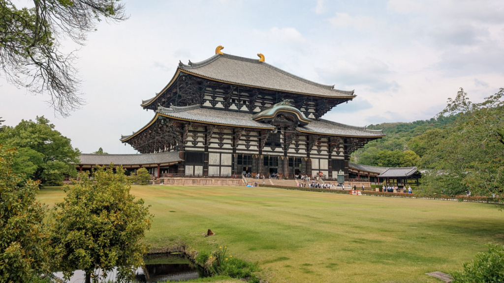 Wide view of the massive wooden Todai-ji Temple Great Buddha Hall across an expansive green lawn in Nara, Japan.